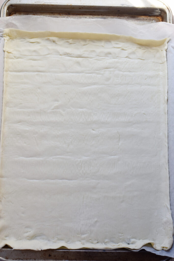 Puff pastry pressed into a baking tray.