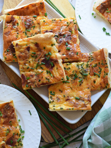 puff-pastry-quiche-squares-image Puff pastry quiche on a white serving plate.