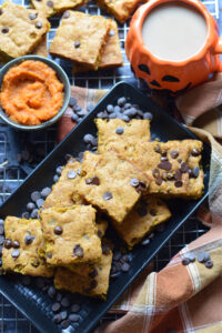 Pumpkin chocolate chip cookie bars on a black plate.