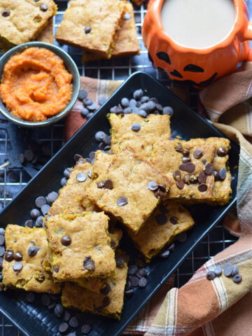 Pumpkin chocolate chip cookie bars on a black plate.
