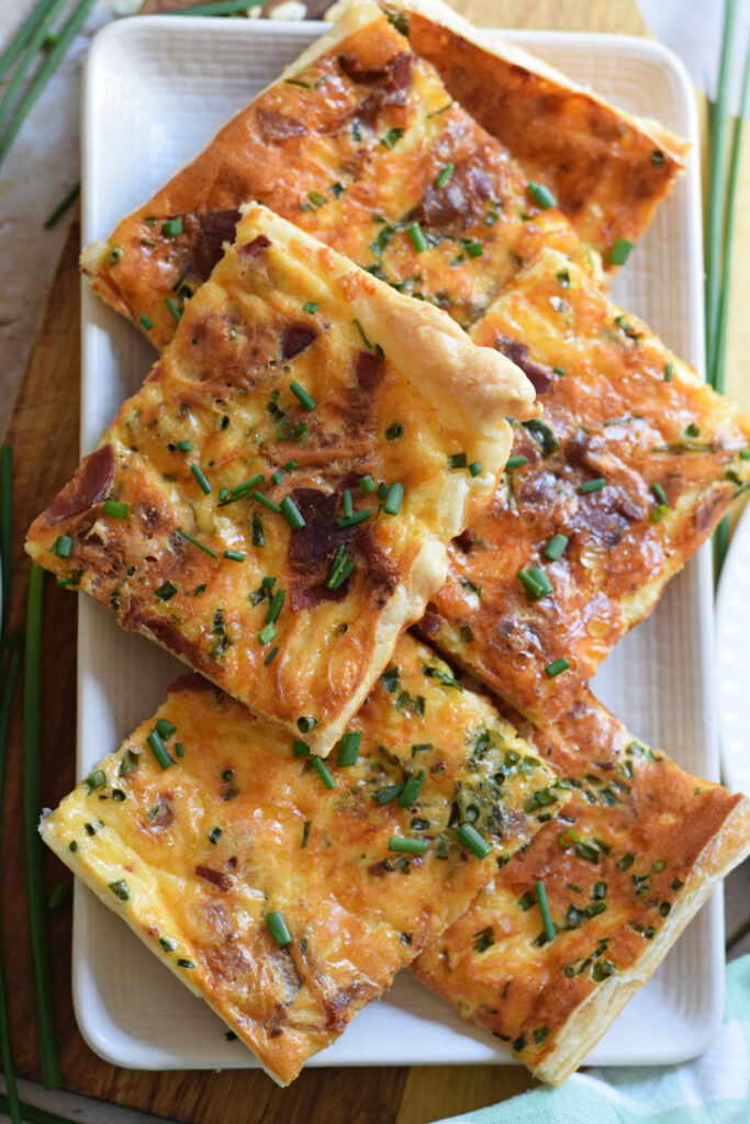 Sheet pan breakfast quiche cut into squares on a plate.