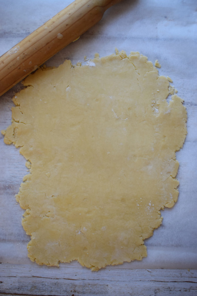 Rolling out pastry to make mini quiche.