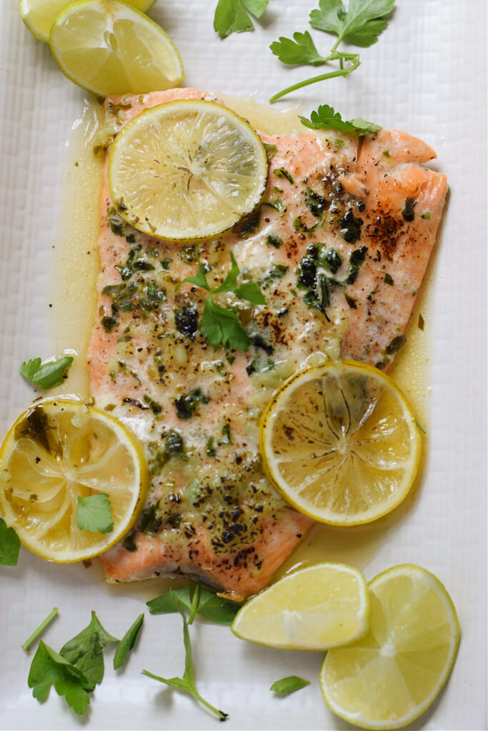 A piece of honey lime salmon on a white plate.