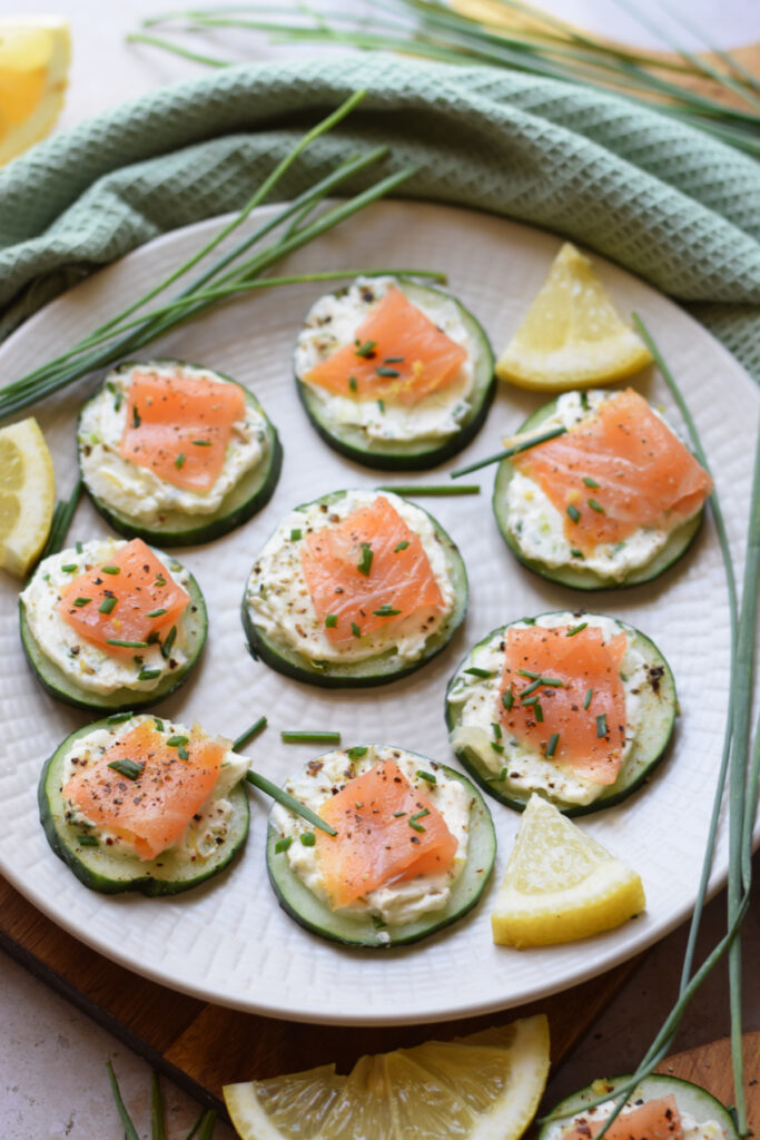 Cucumber smoked salmon bites on a white plate.