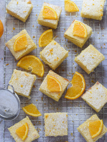 Orange cake squares on a baking rack.