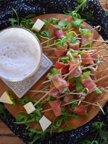 over head view of the Spanish Ham and Cured Cheese Bites with a glass of beer