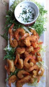 over head view of teh spicy fried shrimp with a minted yogurt dip