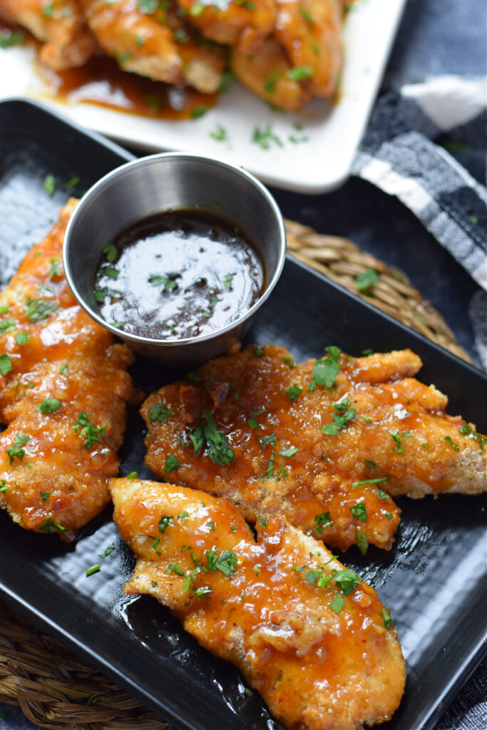 Honey garlic chicken tenders on a plate.
