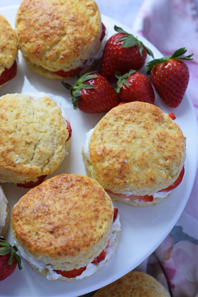Scones and strawberries on a white plate.