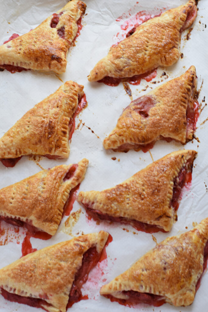 Baked puff pastry turnovers on a tray.